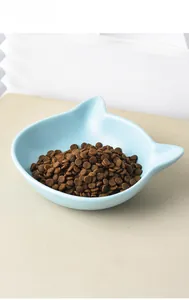 Close-up of light blue cat-shaped ceramic pet bowl filled with brown kibble
