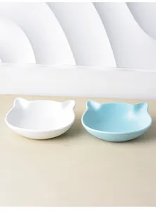 Close-up of ceramic cat ear-shaped bowls in white and sky blue with a smooth glazed finish
