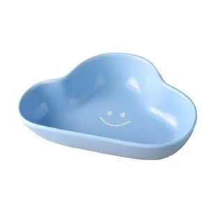 Light blue cloud-shaped ceramic pet bowl with white smiley face and glossy finish