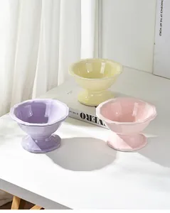 Three elevated ceramic cat bowls in pastel colors with stylish wavy petal edges