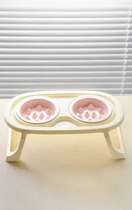Close-up of pink slow feeder pet bowls with elevated stand for cats and dogs