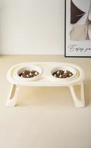 Close-up of beige elevated double pet bowls with white slow feeder columns for cats