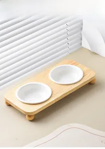Dual white ceramic pet bowls on a raised wooden stand with rounded ball feet