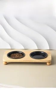 Elevated bamboo pet feeder stand with two black ceramic bowls for cats and dogs