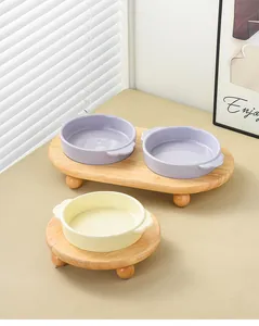 Detail of ceramic cat bowls with elevated wooden stand in light purple and beige tones