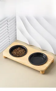 Detail of a raised wooden stand with two black ceramic pet bowls for cats and dogs