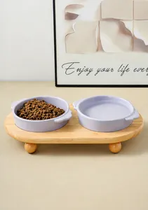 Detalle de dos cuencos cerámicos lavanda en soporte de madera con comida seca y agua fresca
