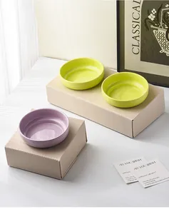 Detailansicht flacher Keramiknäpfe in Neongrün und Lavendel mit glänzender Oberfläche