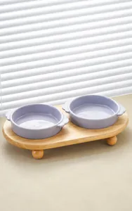 Detalle de cuencos de cerámica lavanda sobre un soporte de bambú con pies de bola