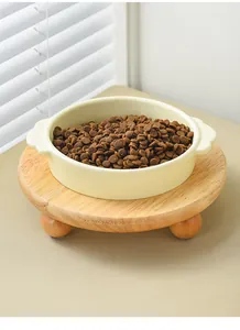 Macro shot of cream ceramic pet bowl on a raised wooden stand with pet food inside