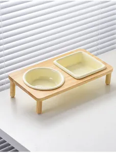 Nahaufnahme von zwei Keramiknäpfen auf einem minimalistischen Eichenholzständer im Licht