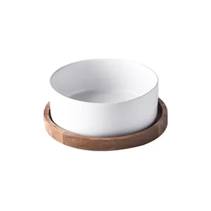 Top view of matte white ceramic pet bowl with natural wood grain acacia tray