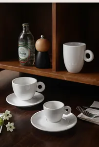 Vue détaillée de tasses à café minimalistes en céramique blanche avec anses en anneau