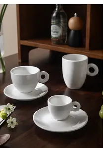 Tasses et soucoupes en céramique blanche minimaliste avec anses en anneau sur bois