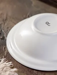 Dettaglio del fondo della ciotola in ceramica bianca con logo cotto a 800 gradi antigraffio