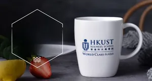 Close-up of a white ceramic mug with logo on a grey stone texture table