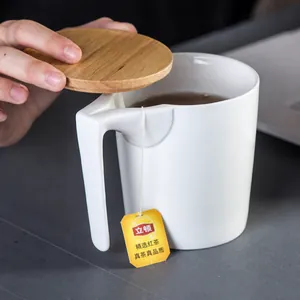 Nahaufnahme einer weißen Keramiktasse mit Holzdeckel und L-förmigem Griff fürs Büro