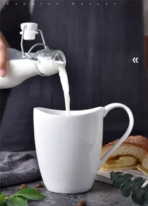 Action shot of pouring fresh milk into a minimalist white ceramic wavy mug with handle