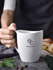 Close-up of a white ceramic mug with an irregular wavy rim and stylish logo print