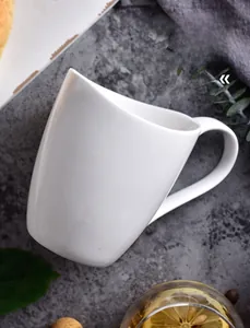 Detailed view of white minimalist ceramic coffee mug with ergonomic handle on stone surface