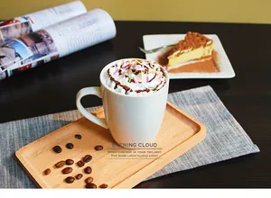 Close-up of minimalist white ceramic coffee mug with whipped cream topping on a wooden tray