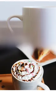Close-up of a white ceramic mug showing the smooth glaze and ergonomic handle detail