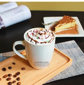 Detail of white ceramic coffee mug with poetic text on a wooden tray with coffee beans