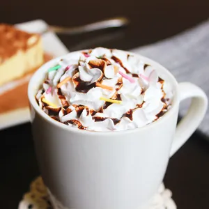 Minimalist white ceramic mug with coffee and whipped cream topping in a cozy setting