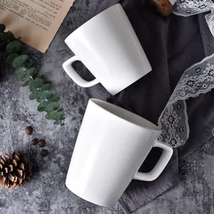 Minimalistisches weißes Keramikbecher-Set mit ergonomischen Griffen auf Textur-Hintergrund
