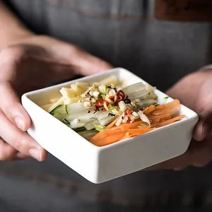 Japanese minimalist white square ceramic dipping bowl held by hand for scale and texture