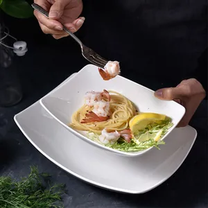 Close-up of white ceramic rectangle plate with pasta and shrimp on a dark background