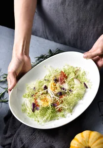 Detail of white ceramic oval plate showing thermal stability from fridge to oven