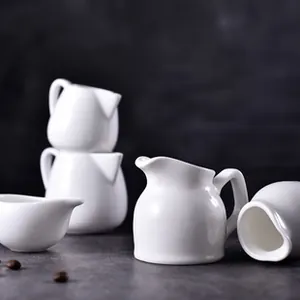 Dettaglio ravvicinato di mini lattiere in ceramica bianca con finitura lucida e manico