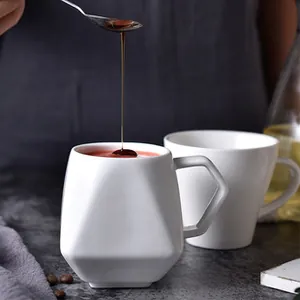 Dettaglio tazza in ceramica bianca geometrica con design a prisma e sciroppo