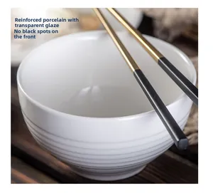 Detail of white ceramic bowl with horizontal ridges and transparent glaze finish