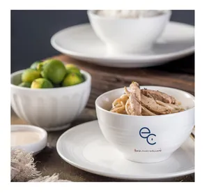 Detailed macro view of white ceramic bowls with horizontal ribbed texture and blue logo