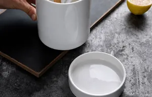 Close-up of white ceramic utensil holder with heat resistant glazed finish and tray
