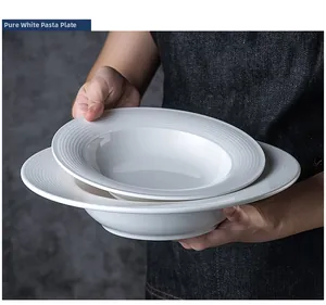 Person holding white ladder rim ceramic pasta plate showcasing texture and size