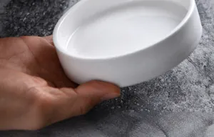 Close-up of smooth polished glaze on a white ceramic sauce dish for kitchen use