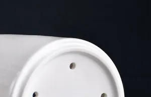 Detail view showing drainage holes of white ceramic chopstick holder with smooth glazed finish