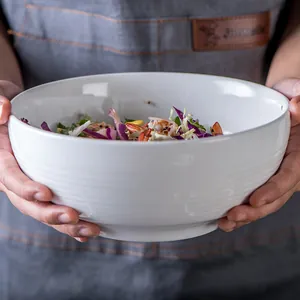 Nordic white ceramic salad bowl with ribbed texture held in hands showing food capacity