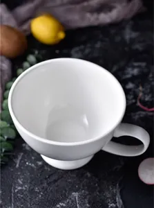 Macro shot of white ceramic breakfast mug with thick walls and ergonomic handle