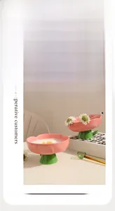 Détail d'un bol pour chat en céramique rose en forme de fleur avec support vert surélevé