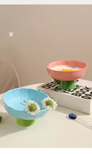 Détail d'un bol surélevé en céramique pour animaux avec bords festonnés rose et bleu