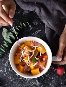Macro shot of fresh fruit salad inside a white ceramic bowl with high water resistance