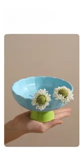 Détail du bol en céramique bleue pour animaux avec bord ondulé et base surélevée verte