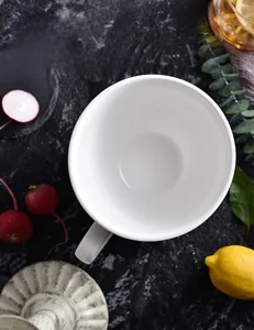 Top view of white reinforced porcelain mug with a transparent glaze on marble background