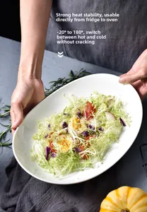 Nahaufnahme einer weißen ovalen Keramikplatte mit frischem Salat auf rustikalem Grund