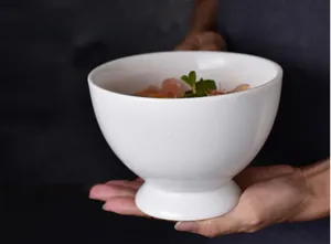 Close-up of a white ceramic goblet bowl with smooth glaze holding fresh grapefruit and mint