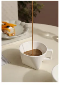 Dynamic pouring of coffee into a minimalist white ceramic mug with geometric design